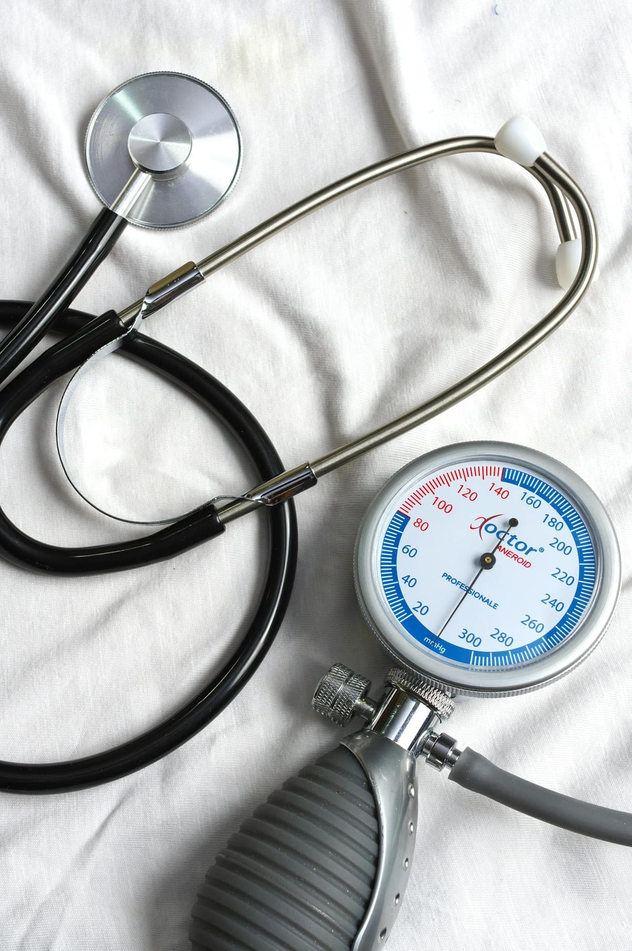 A stethoscope and blood pressure gauge resting on a white cloth